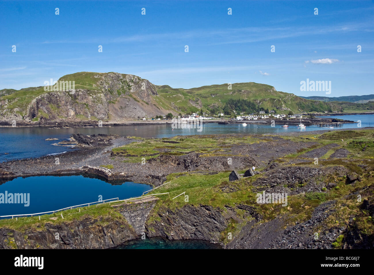 General view of  village Easdale on Seil across the water from the disused slate quarries on the Island of Easdale in Scotland. Stock Photo