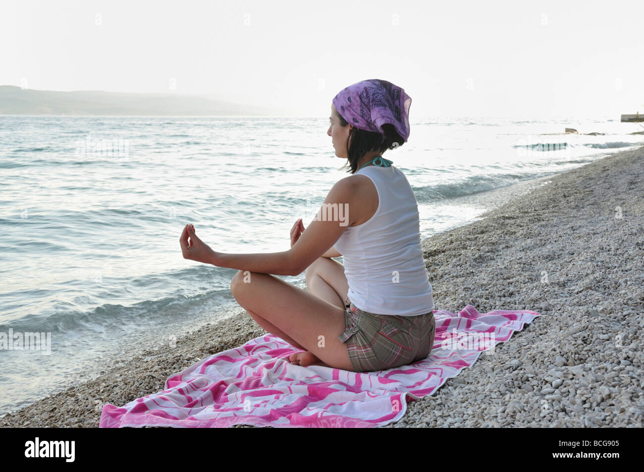 Young woman doing yoga on beach Stock Photo