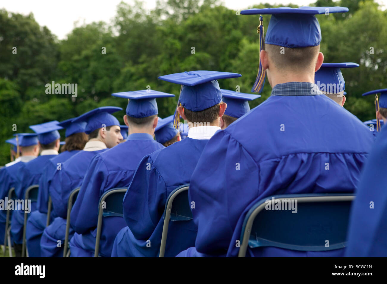 High School students wearing blue and gold cap and gown attend