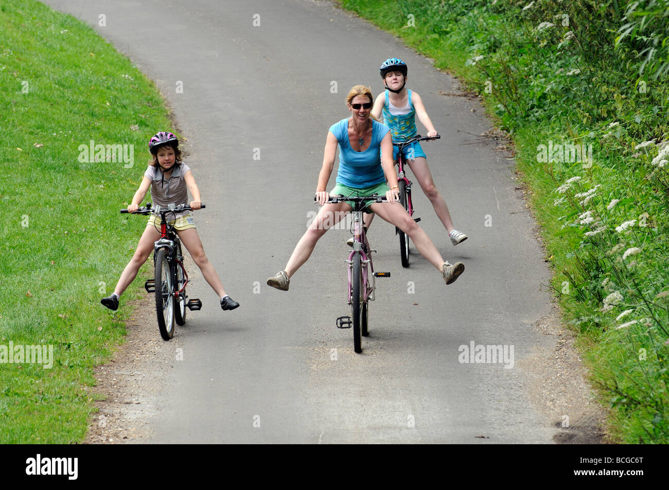 Female cyclist and children riding with their legs outstretched Cycling
