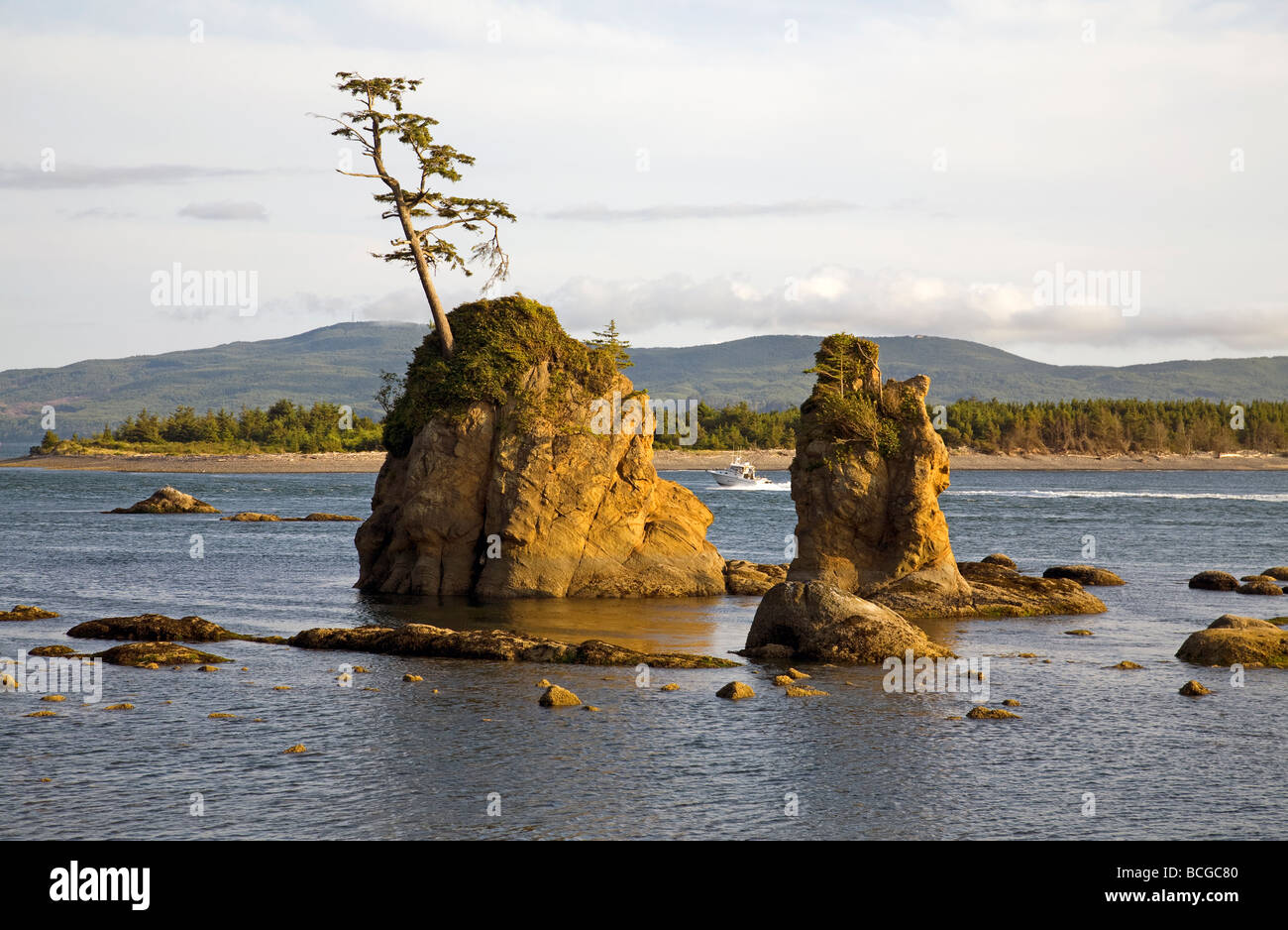 A fishing boat heads past sea stacks into the Tillamook Bay near the