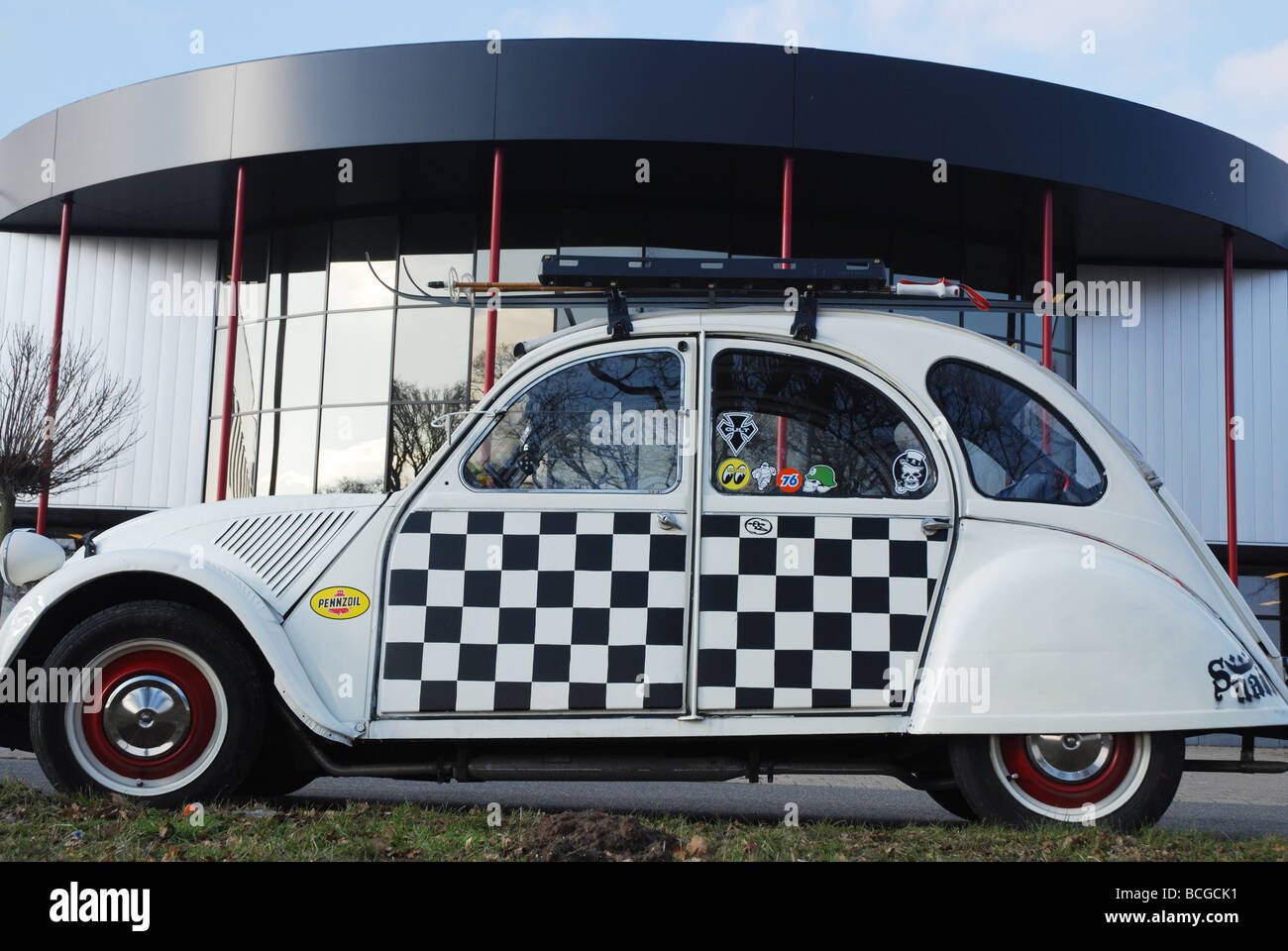 chequered Citroen deux chevaux parked by roadside Stock Photo