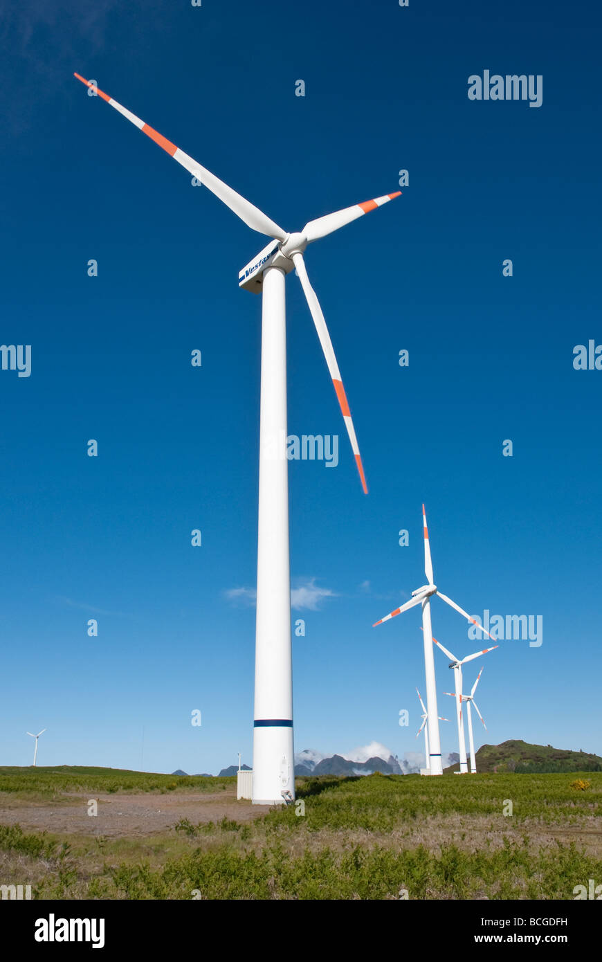 Wind turbines on hill, with blue sky Stock Photo - Alamy