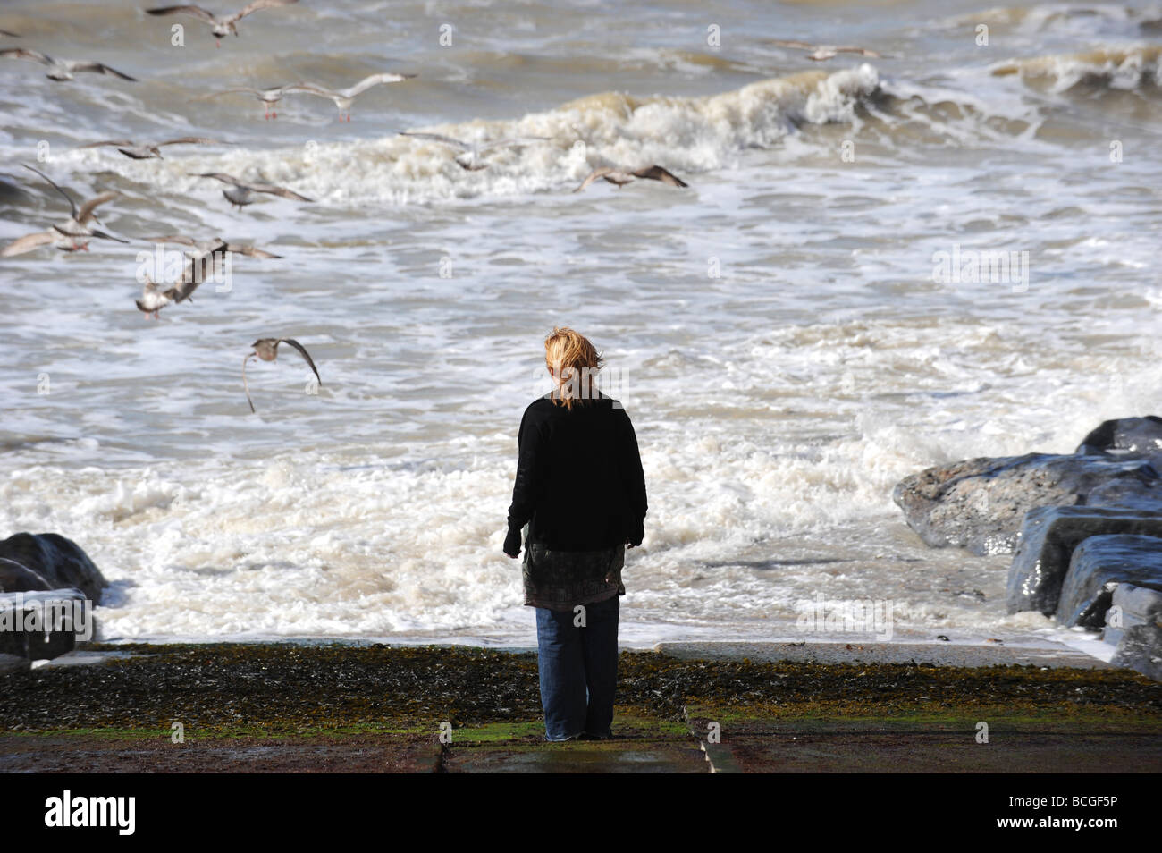 Woman looking out to stormy sea hi-res stock photography and images - Alamy