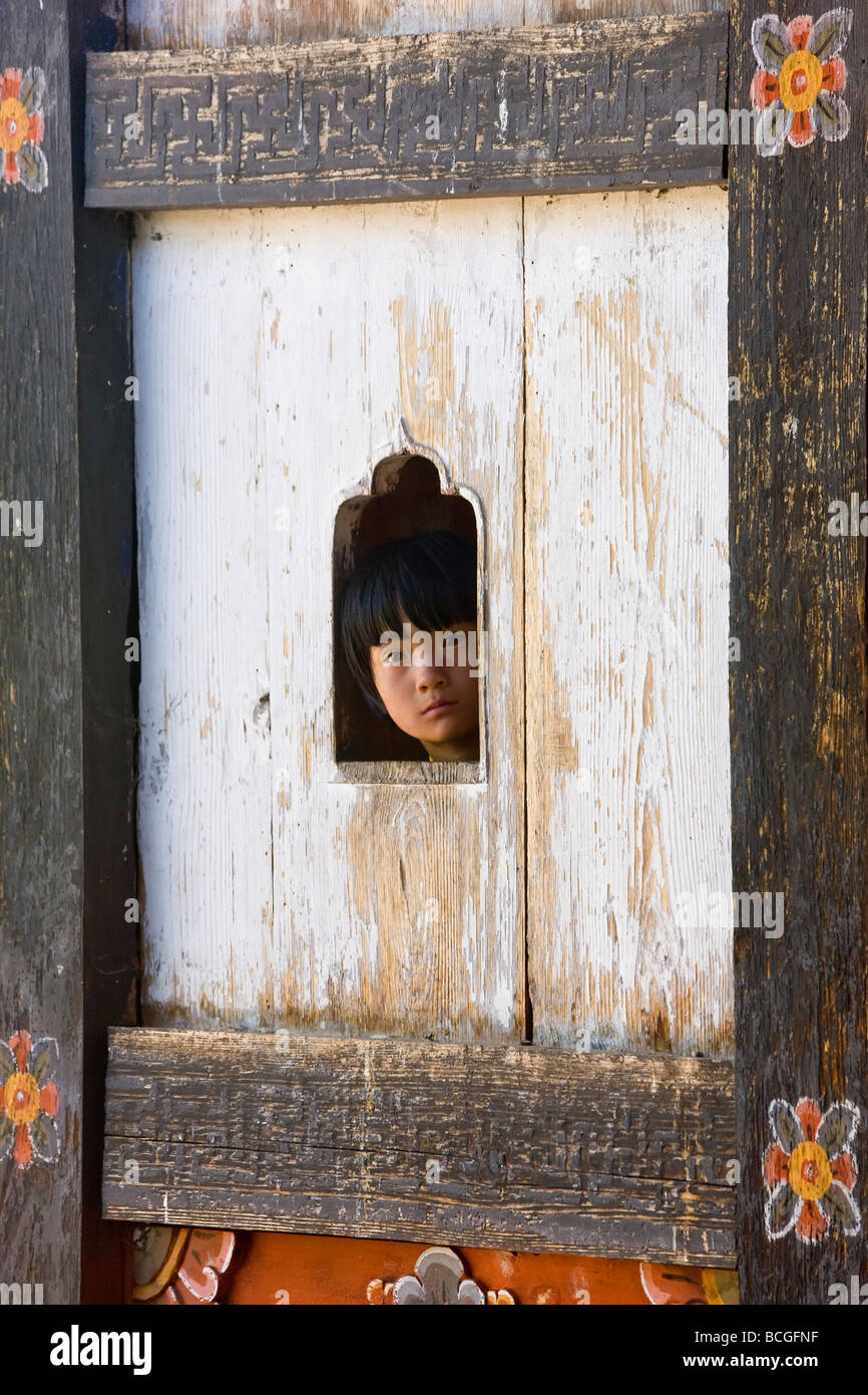 Girl at window watching festival Thangbi Mane Festival Tangbi Goemba nr Jakar Bumthang Bhutan Stock Photo