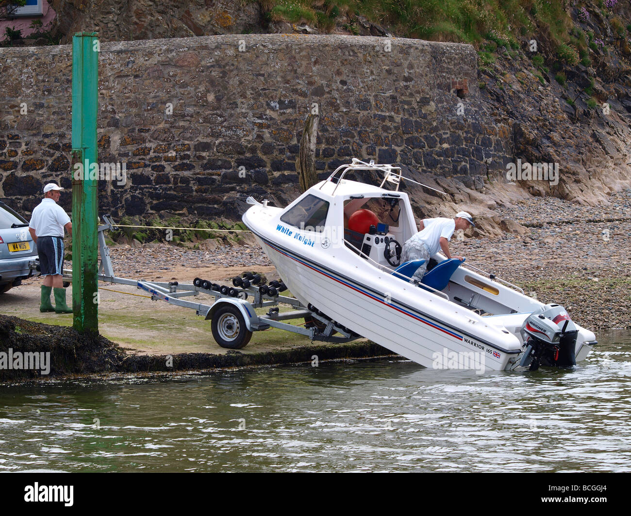 Lowering a boat into the water from of a trailer Stock Photo Alamy