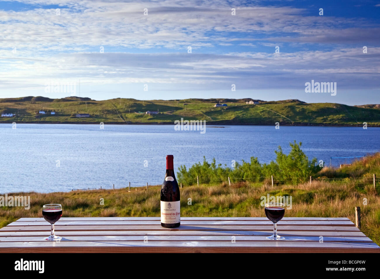 Wine bottle and glasses on a garden table overlooking Loch Roag, Isle of Lewis, Outer Hebrides, western isles, Scotland, UK 2009 Stock Photo