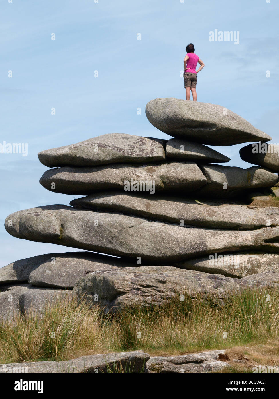 Woman stood on top of rocks on the edge of the Cheesewring Quarry Bodmin Moor Cornwall Stock Photo