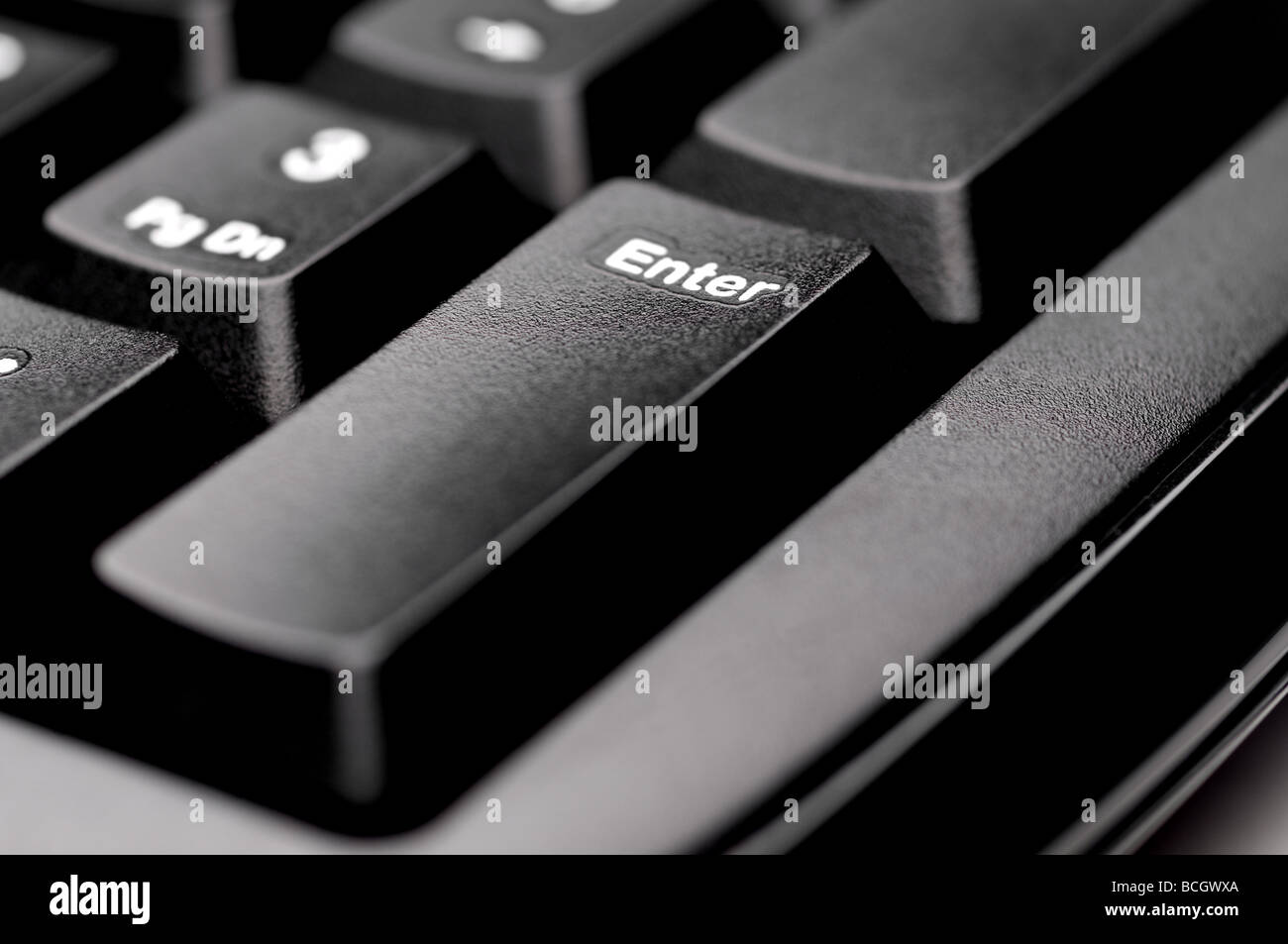 Horizontal shallow focus macro of an Enter key on a black computer keyboard Stock Photo