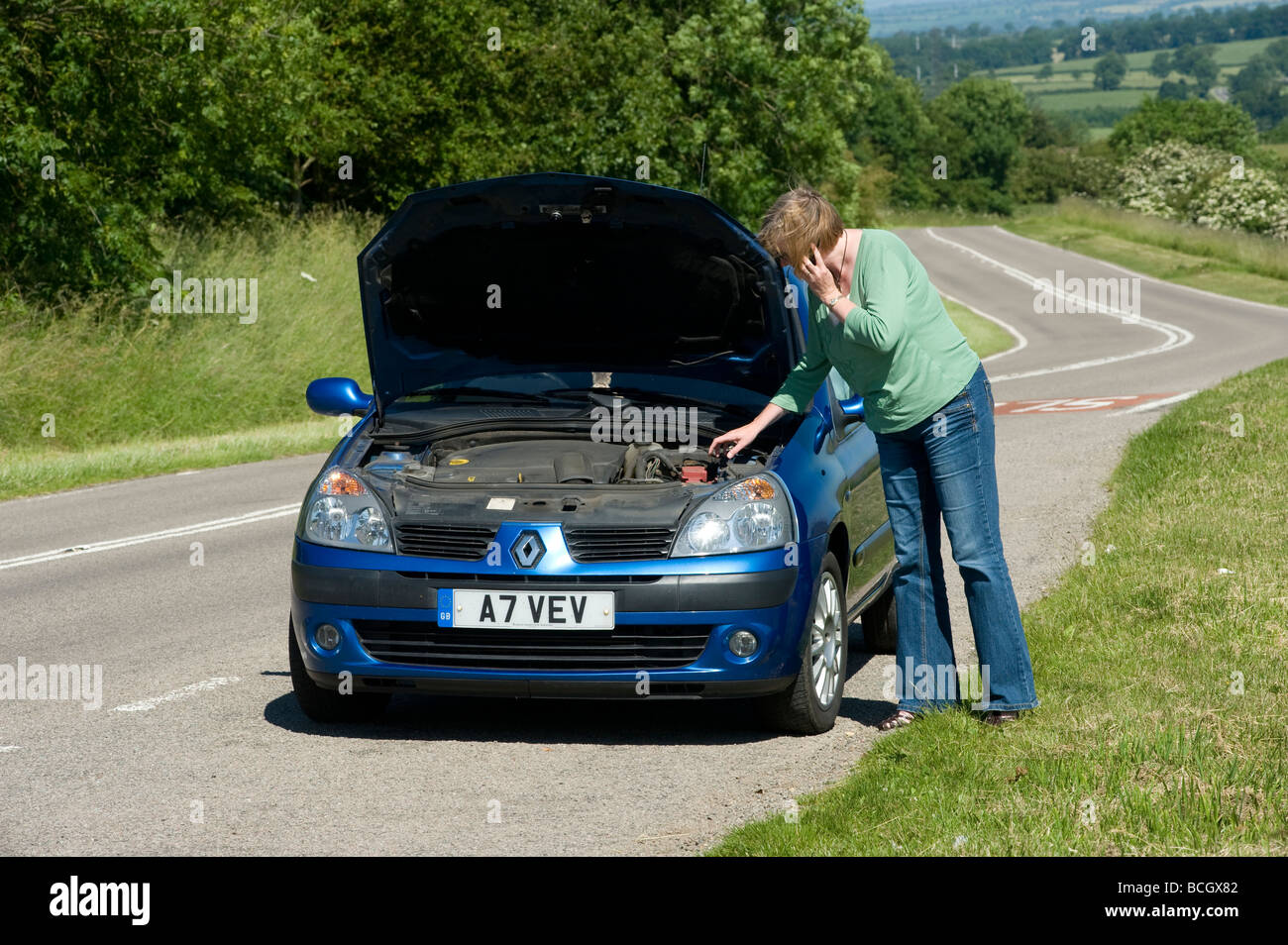 Lone Woman With A Broken Down Car Calling For Help On A Mobile Phone Stock Photo Alamy