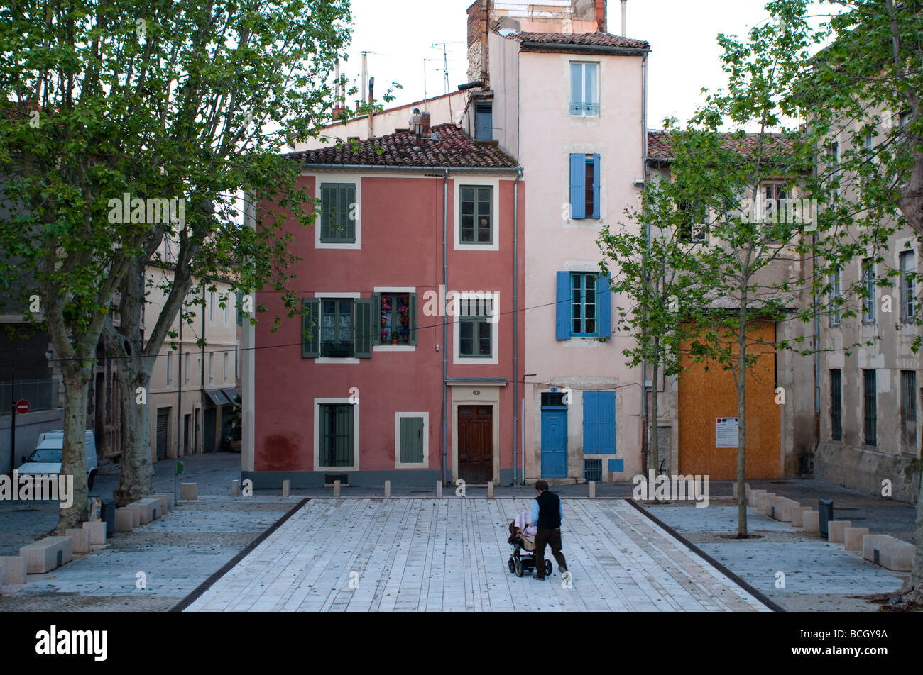 Lovely square Man pushing a pushchair Nimes France Stock Photo