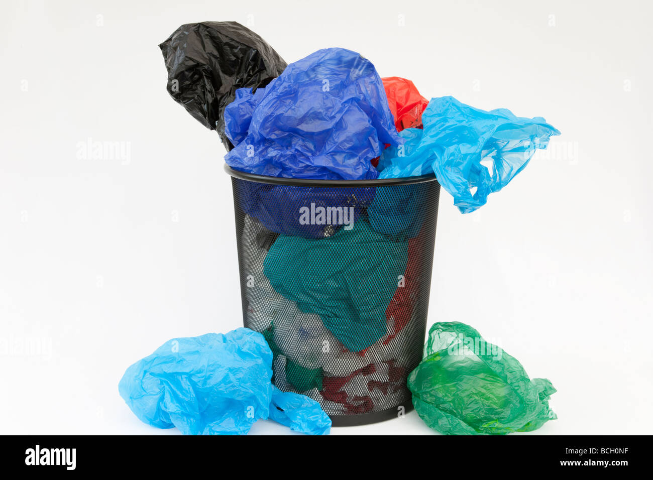 Disposable single-use non-biodegradable plastic shopping carrier bags in a waste bin on a white background. England Britain UK Stock Photo