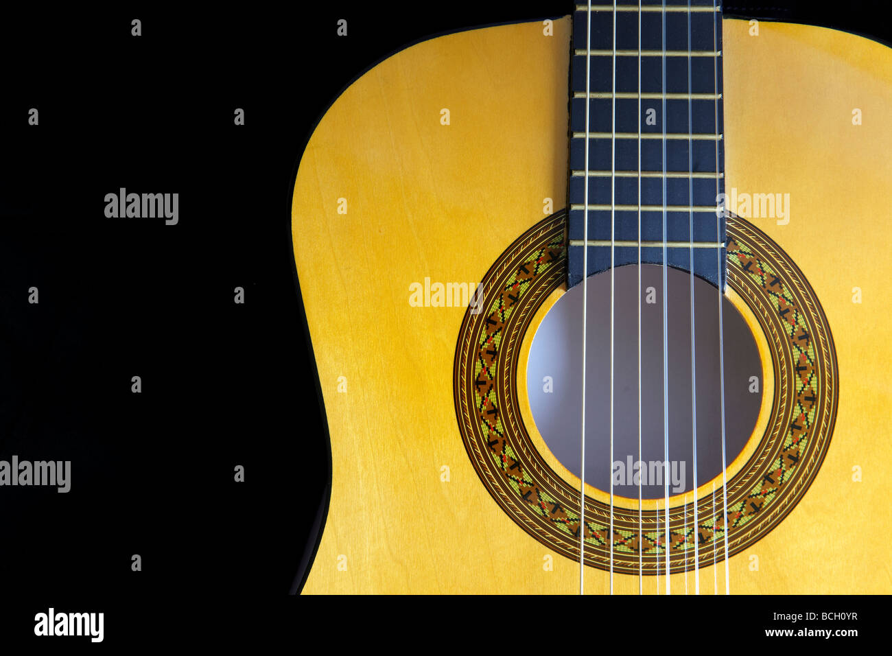 close up view of fretboard and sound hole of guitar on black with space for copy Stock Photo