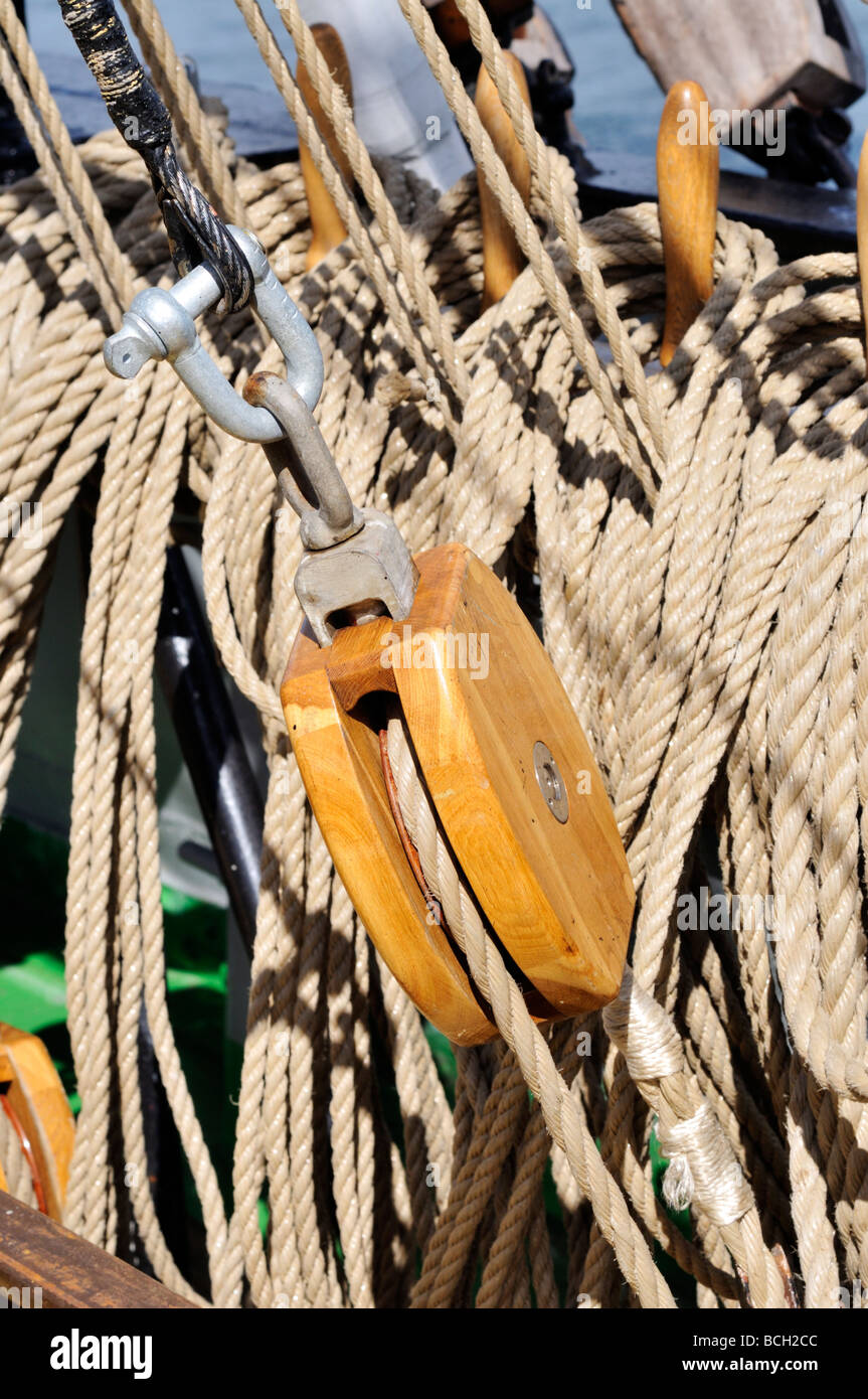 Single wood block surrounded by furled lines and rigging on large sailing vessel Stock Photo