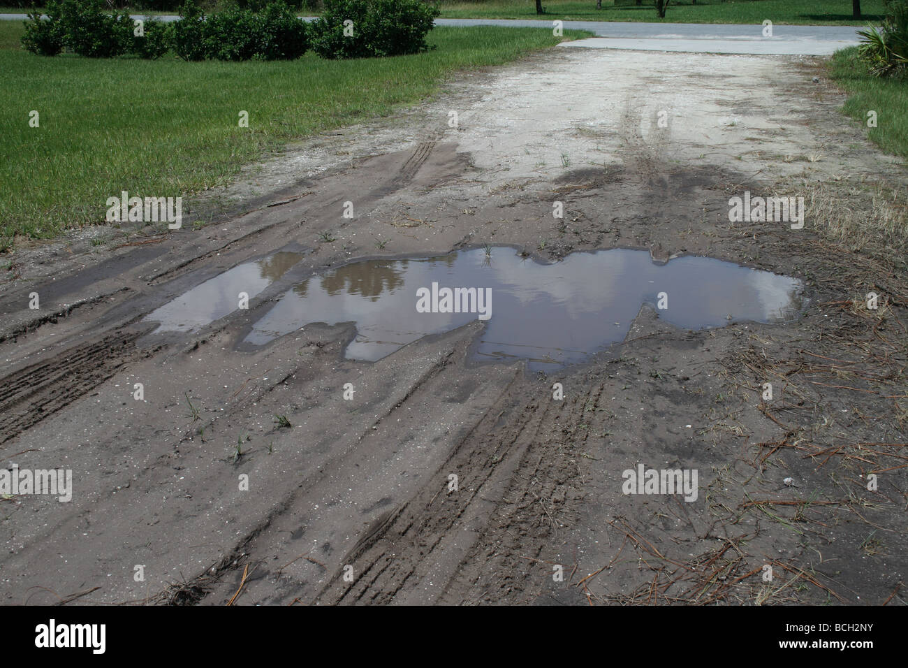 Puddle in dirt driveway Stock Photo Alamy