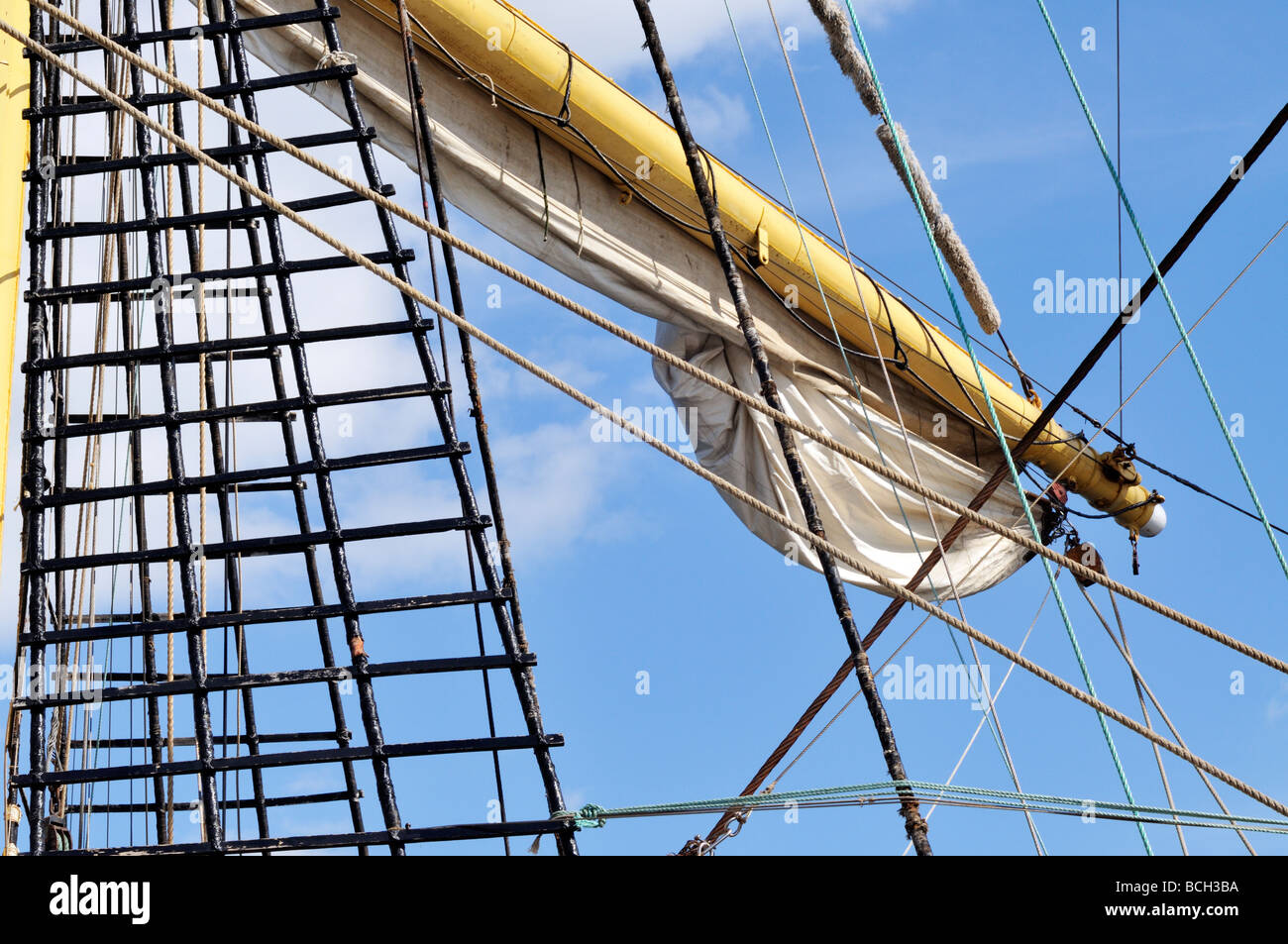 Sailing ships spar and shroud with rigging lines and furled sail Stock Photo