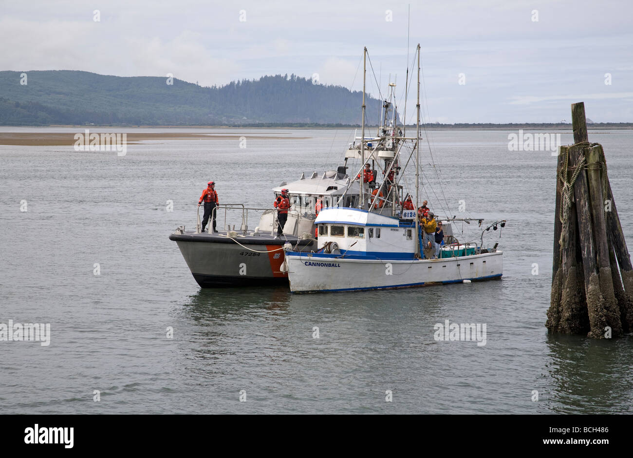 A US coast guard cutter rescues a stranded fishing boat in Tillamook Bay near the town of Garibaldi on the Oregon Pacific Coast Stock Photo