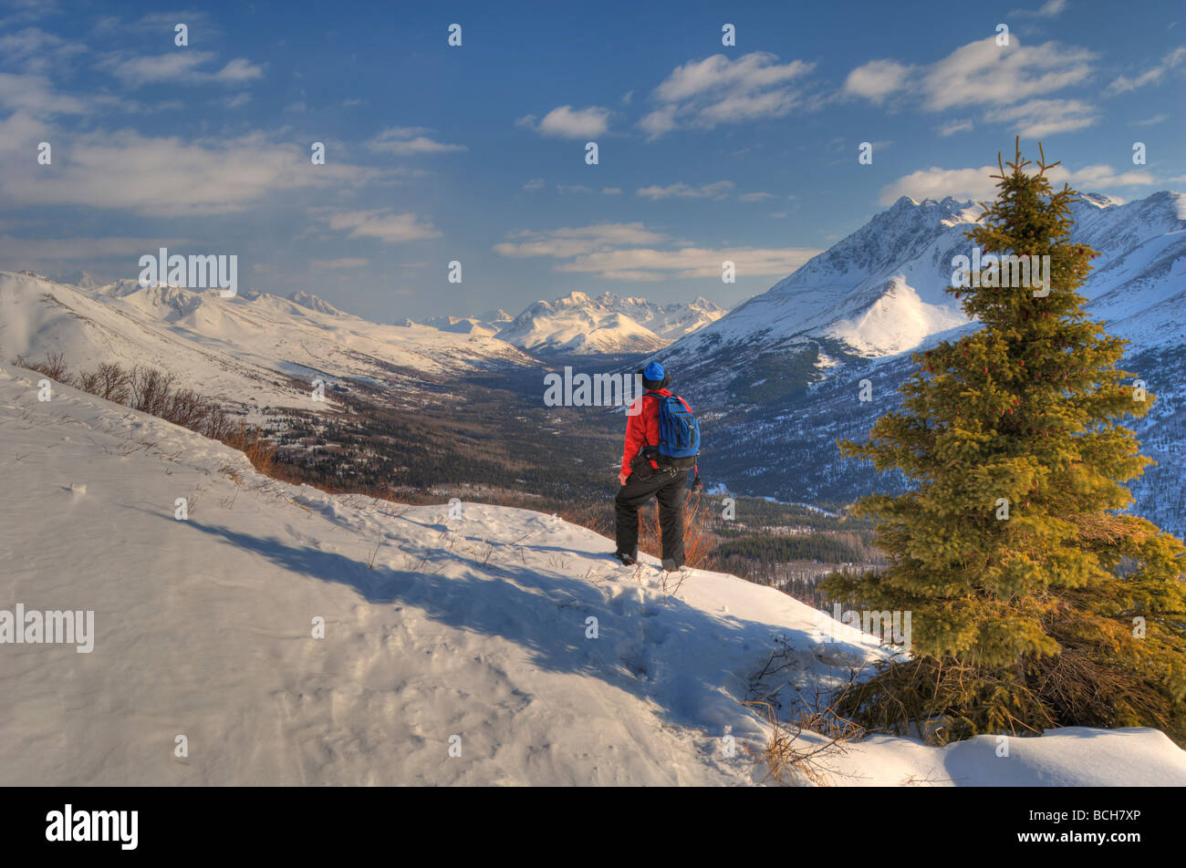Man snowshoeing above Arctic Valley with Chugach Mountains in the background, Southcentral Alaska Stock Photo