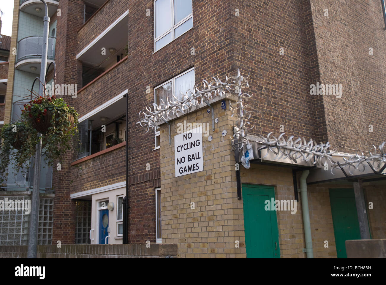 London housing estate with razor wire and no cycling and ball games sign Stock Photo