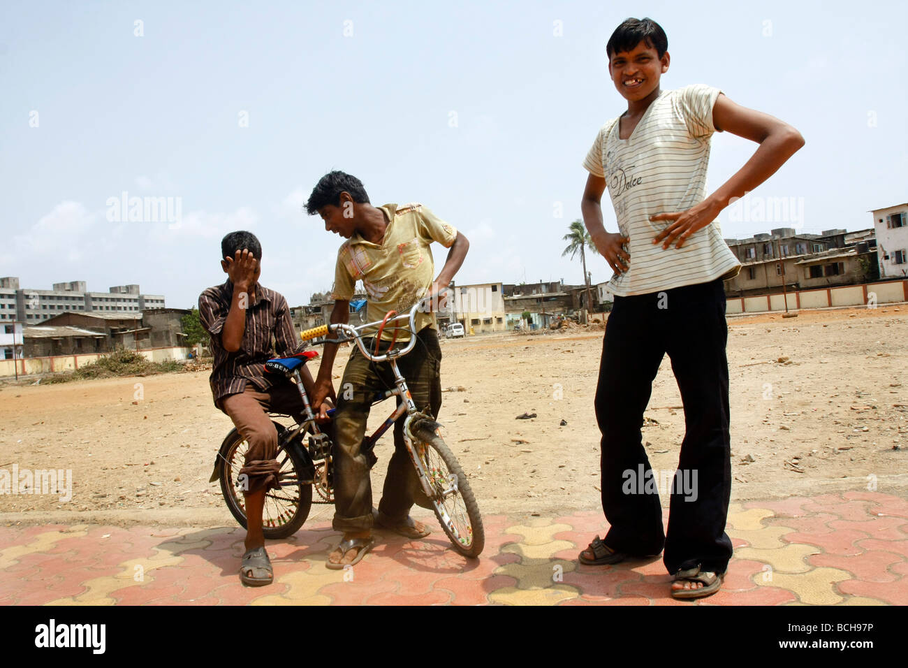 Boys ride a bicycle on a playground in the poor slum area of Dharavi in Mumbai (Bombay) in India. Stock Photo