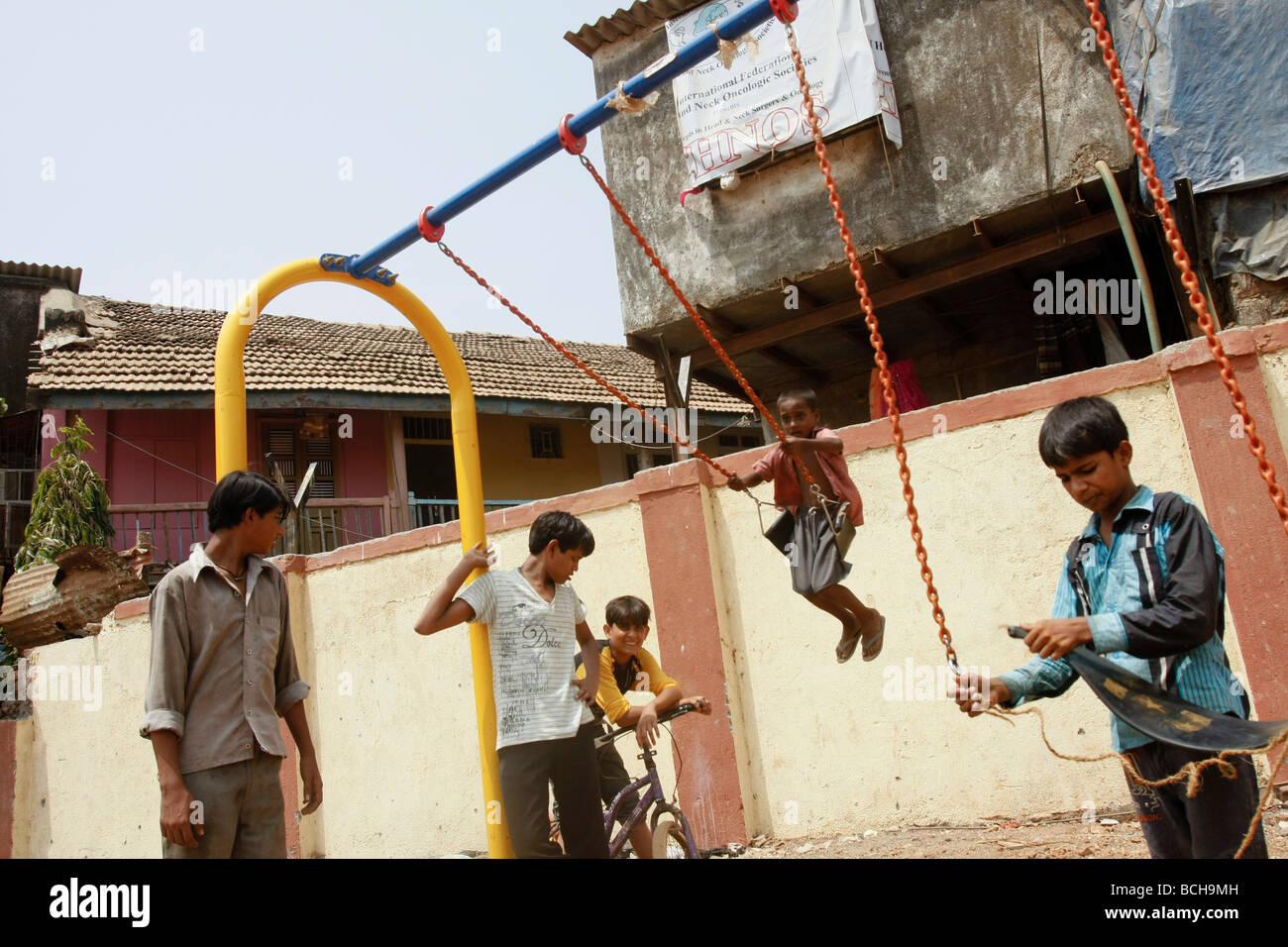 Children play on a set of newly built swings in Dharavi, the largest slum area in Mumbai (Bombay) in India Stock Photo