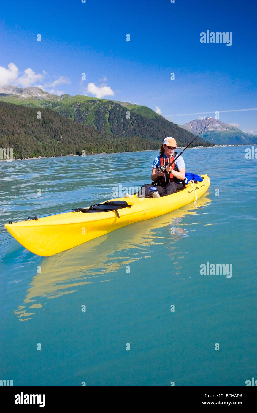 Female fishrewoman in kayak fishing for halibut in Resurrection