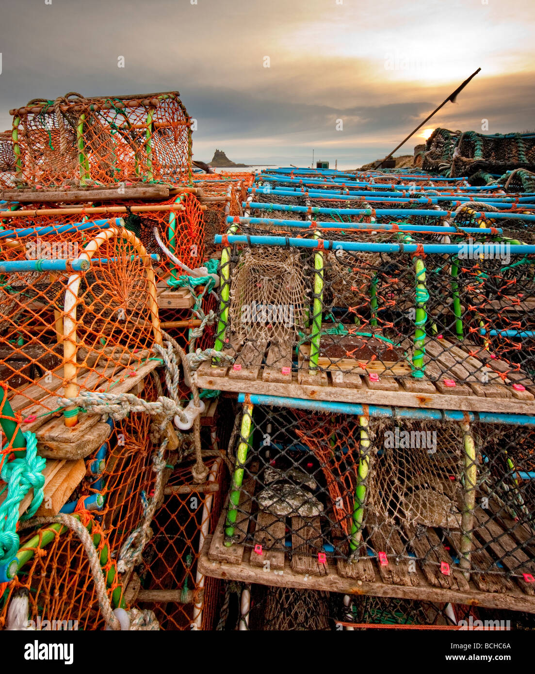Looking across lobster pots to Lindisfarne Castle Northumberland Stock Photo