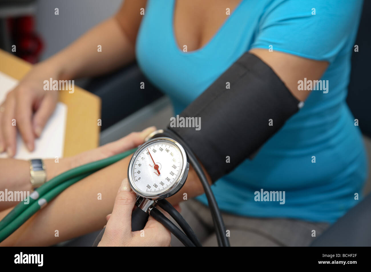 Physician with stethoscope measures blood pressure of a patient Stock