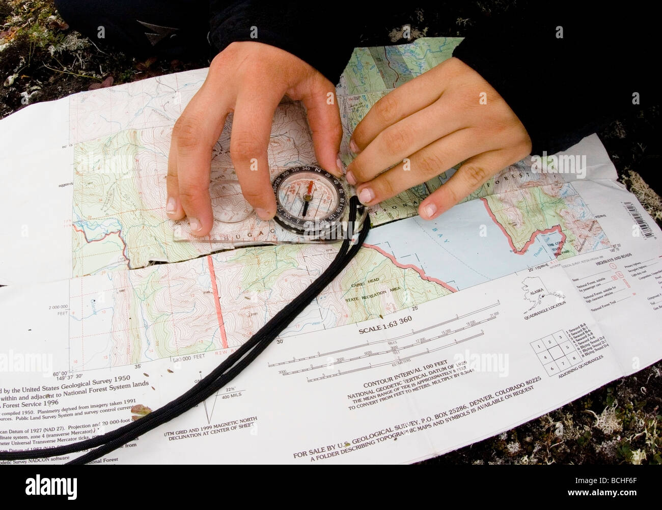 View of hands, compass, & map as backpacker navigates Resurrection Peaks area Seward Alaska Kenai Peninsula Summer Stock Photo