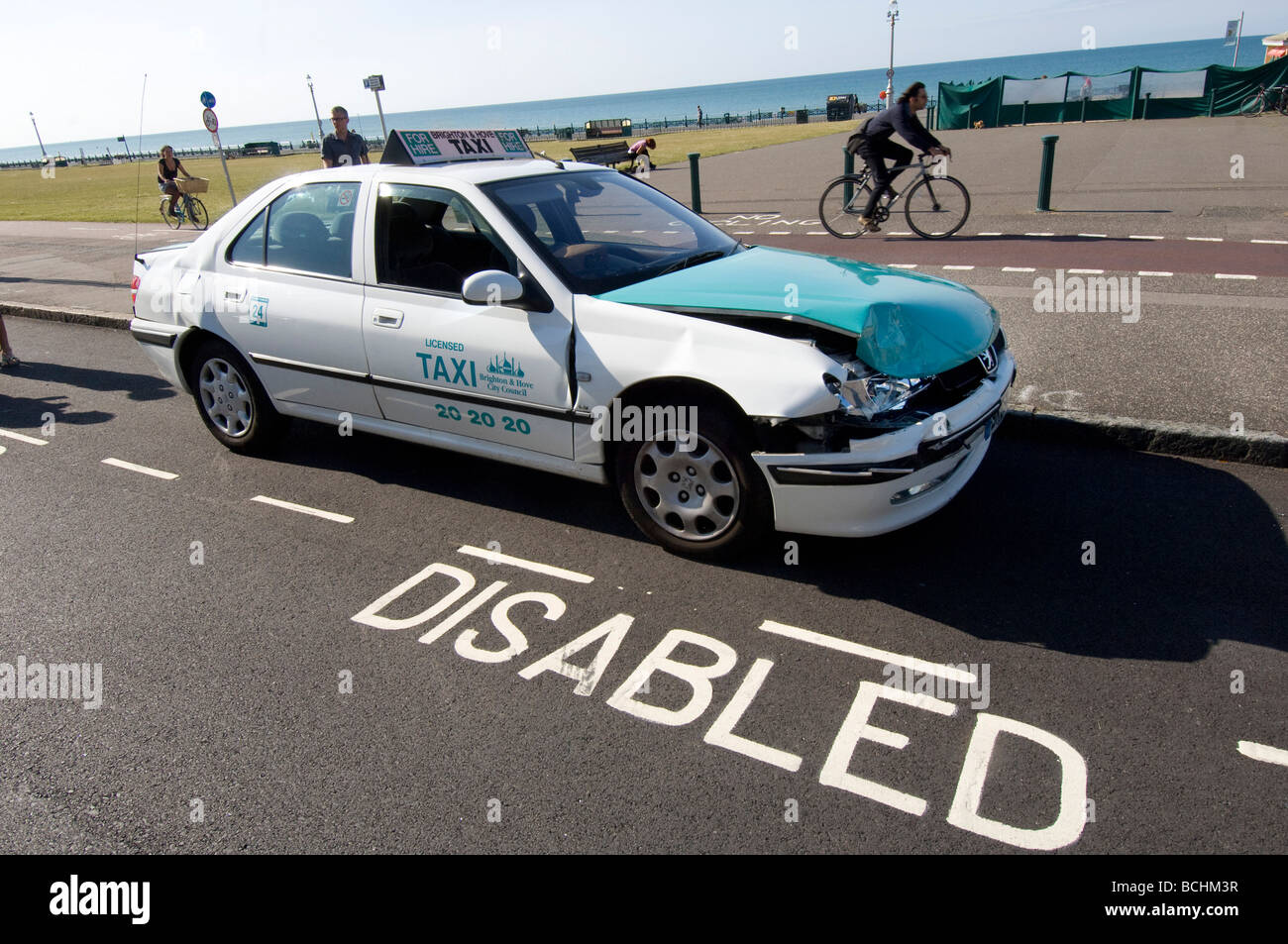 A damaged cab, after a road accident, parked in a disabled bay Stock Photo