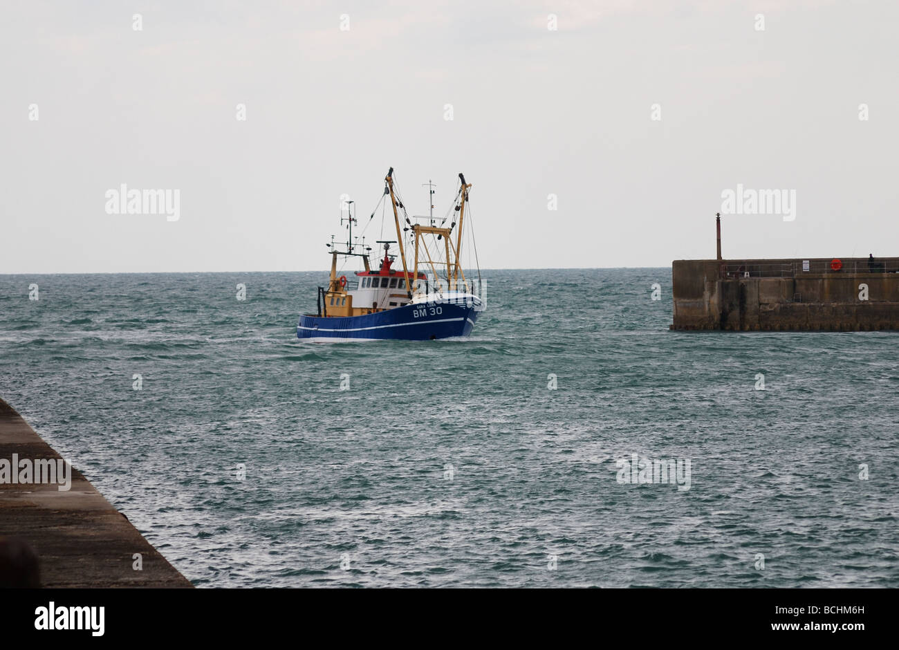 A fishing boat returning to port Stock Photo