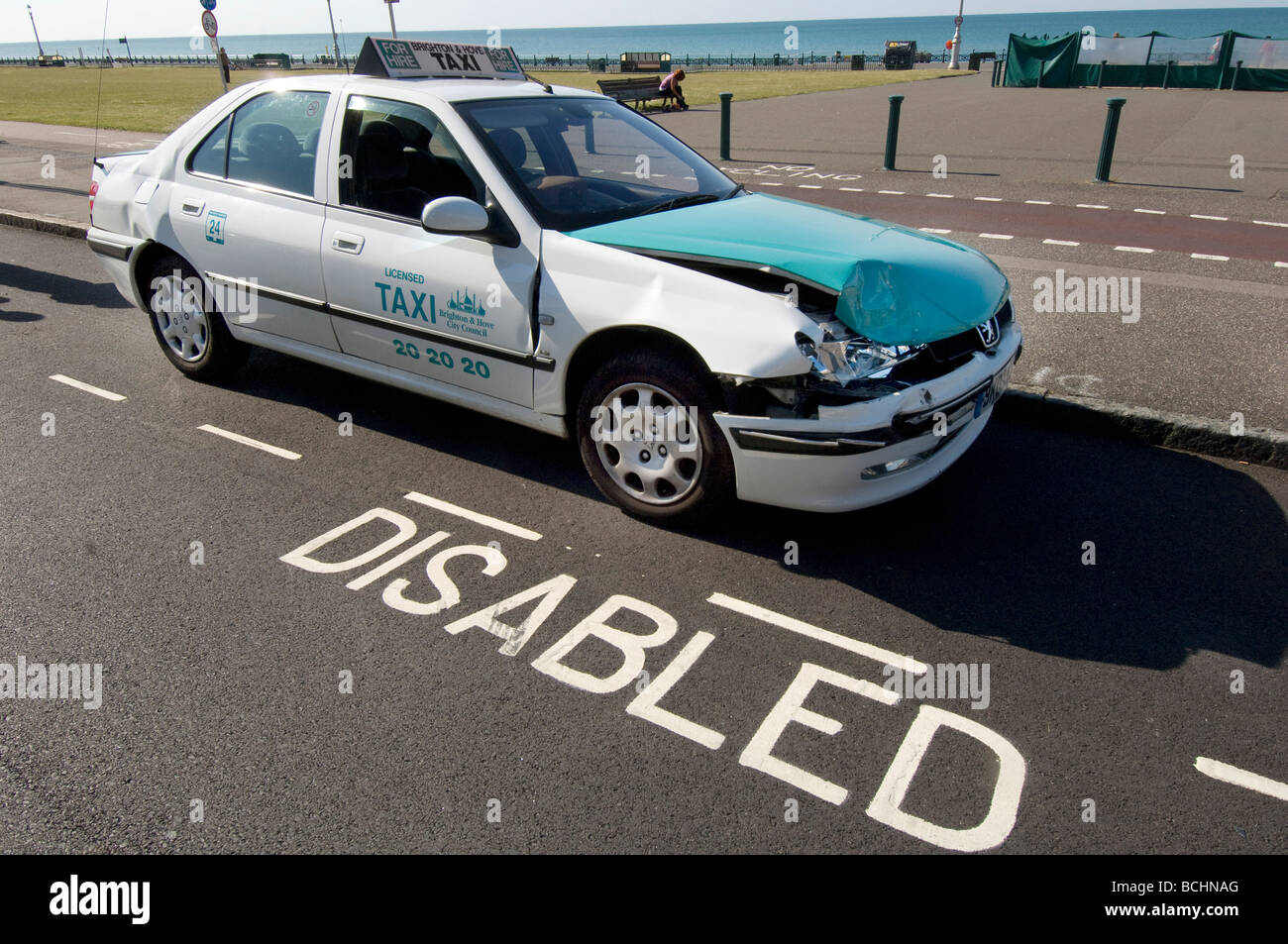 A Brighton taxi with a dented wing and bonnet in a disabled parking bay Stock Photo
