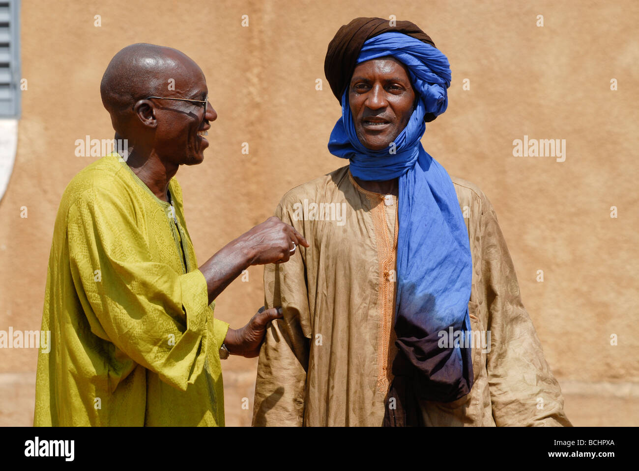 Western Africa , Mali , two men have a talk in village, the wear a boubou made from damask fabric Stock Photo
