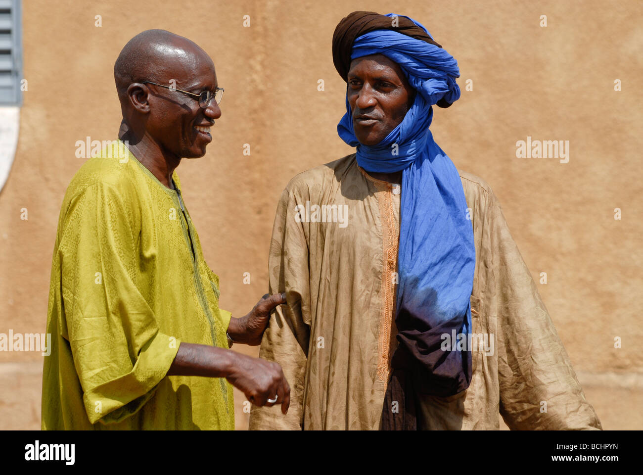 Western Africa , Mali , two men have a talk in village, the wear a boubou made from damask fabric Stock Photo