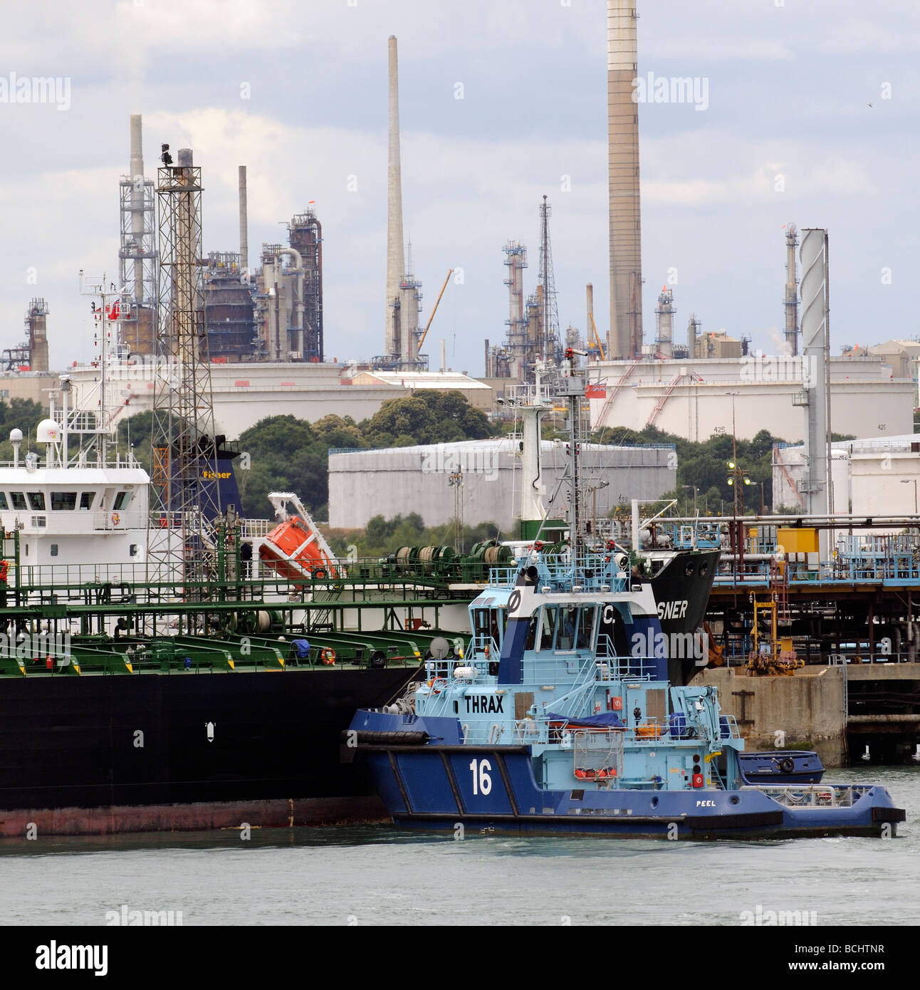 Marine Terminal Fawley Southampton England UK the oil tanker T C Gleisner being moved into position by docking tugs Stock Photo