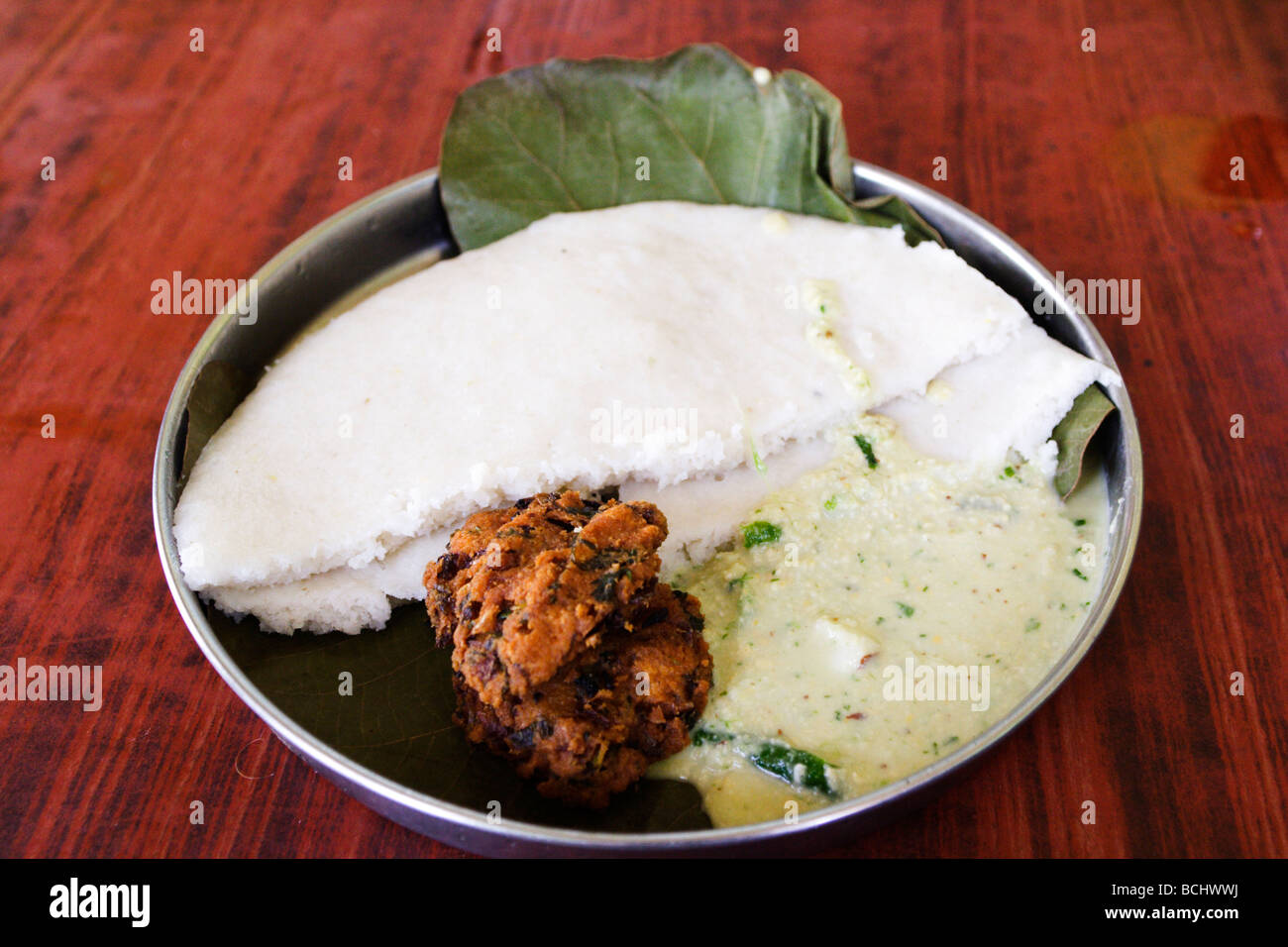 A traditional breakfast is served in an inexpensive restaurant in Mysore, India. Malliga Idly and Vada are served with chutney. Stock Photo
