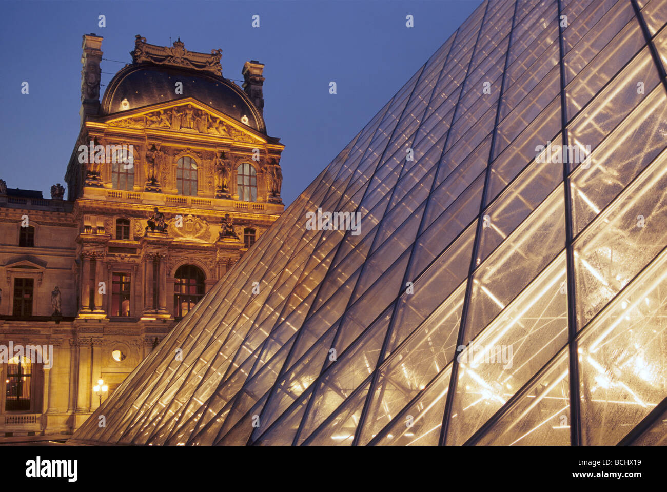 Illuminated Pyramid and Pavillon Denon at Musee du Louvre at night in Paris France Stock Photo