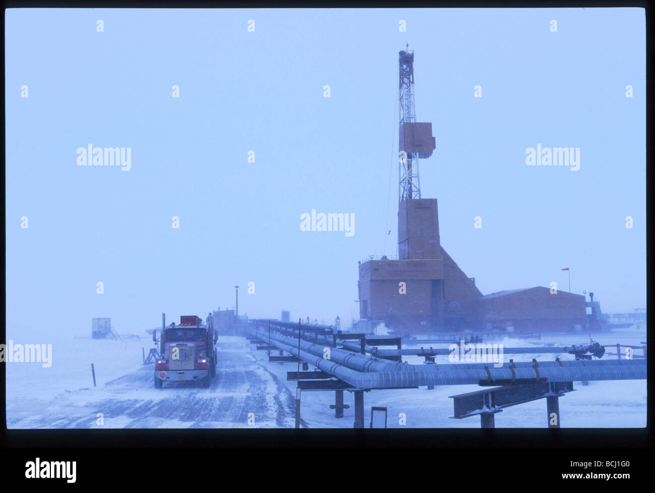 Oil Rig & truck driving on road Prudhoe Bay Arctic AK winter scenic Stock Photo