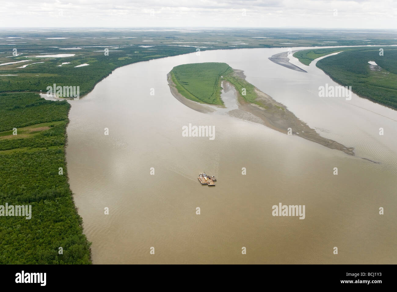 Aerial of Tug pushing barge upriver on Kuskokwim River near Akiachak