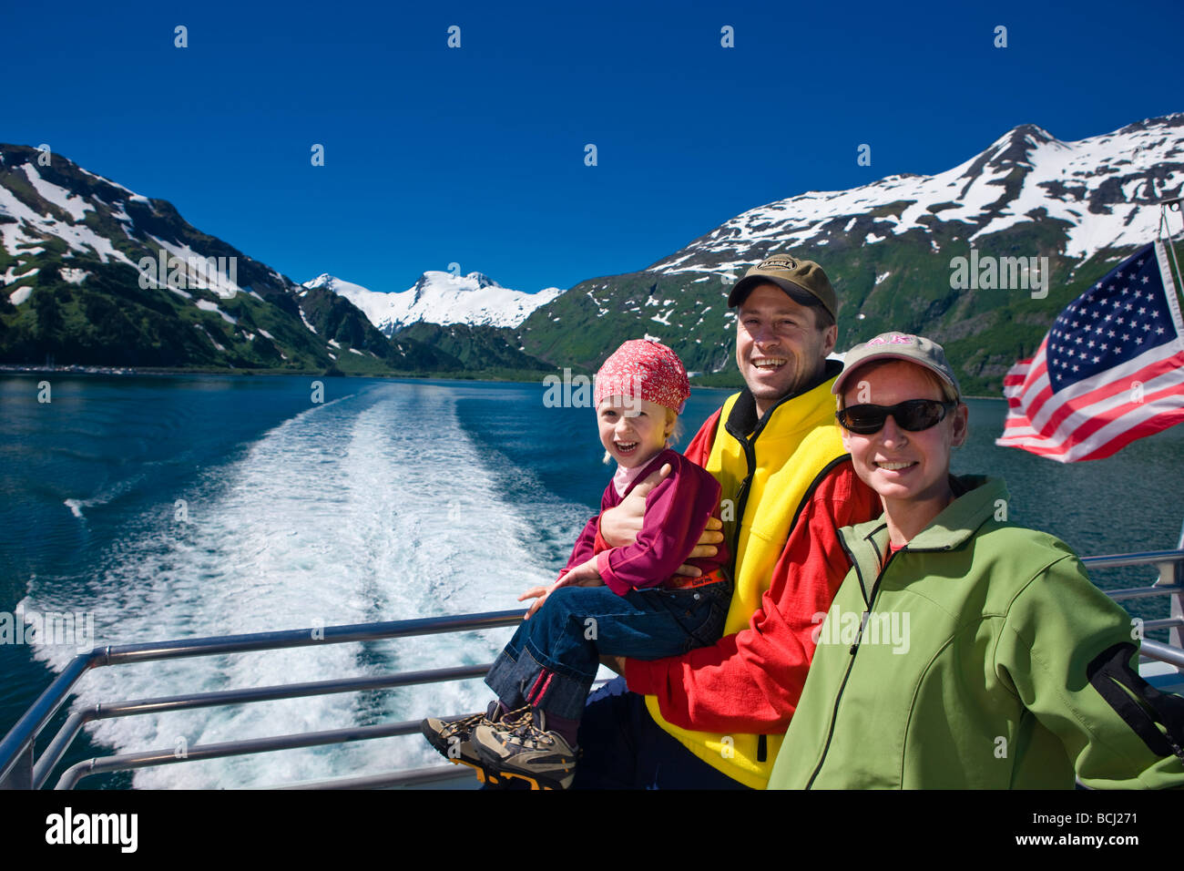 Tourists on the back deck of the Klondike Express tour boat as it leaves port in Whittier, Prince William Sound, Alaska Stock Photo