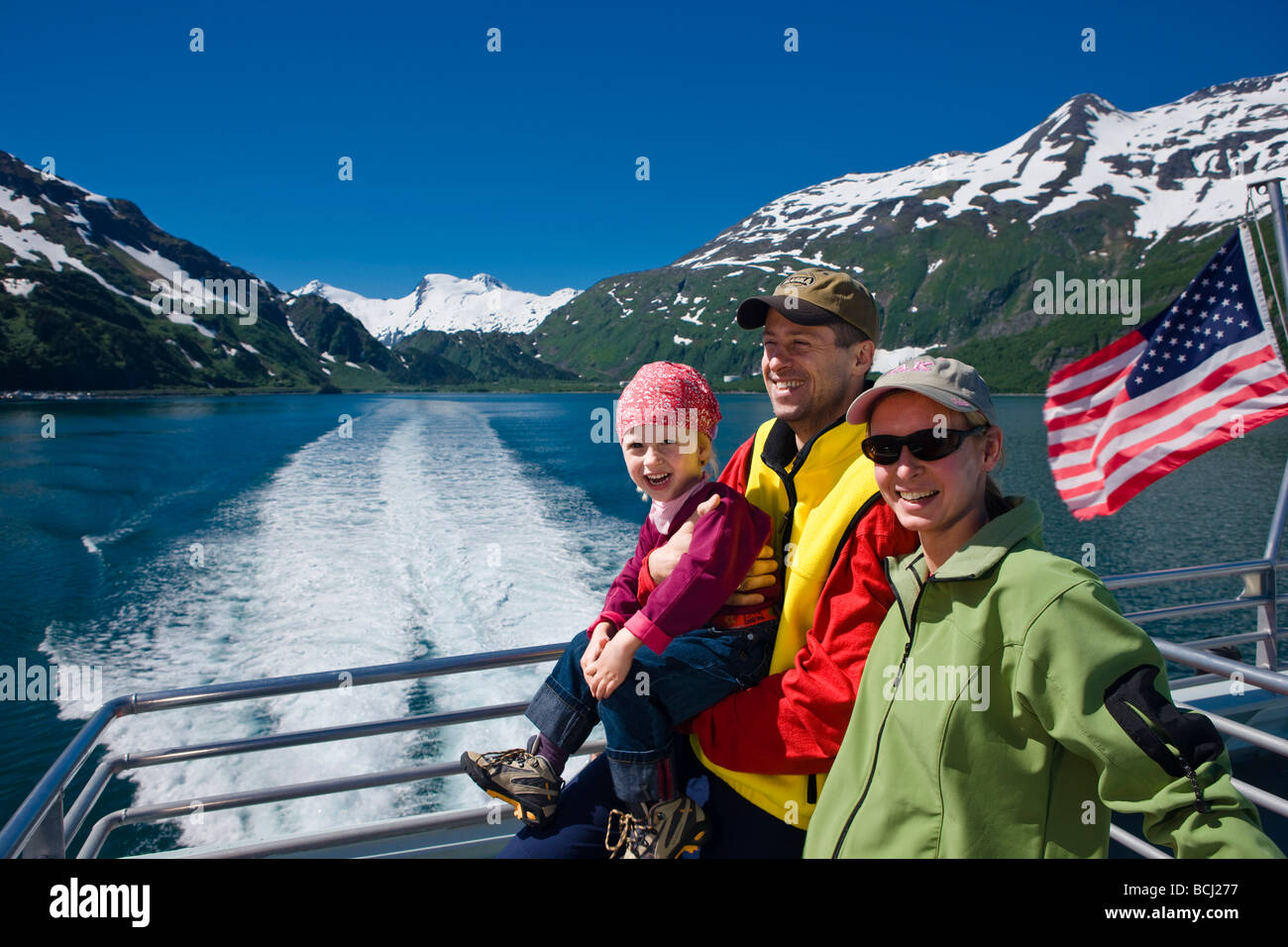 Tourists on the back deck of the Klondike Express tour boat as it leaves port in Whittier, Prince William Sound, Alaska Stock Photo