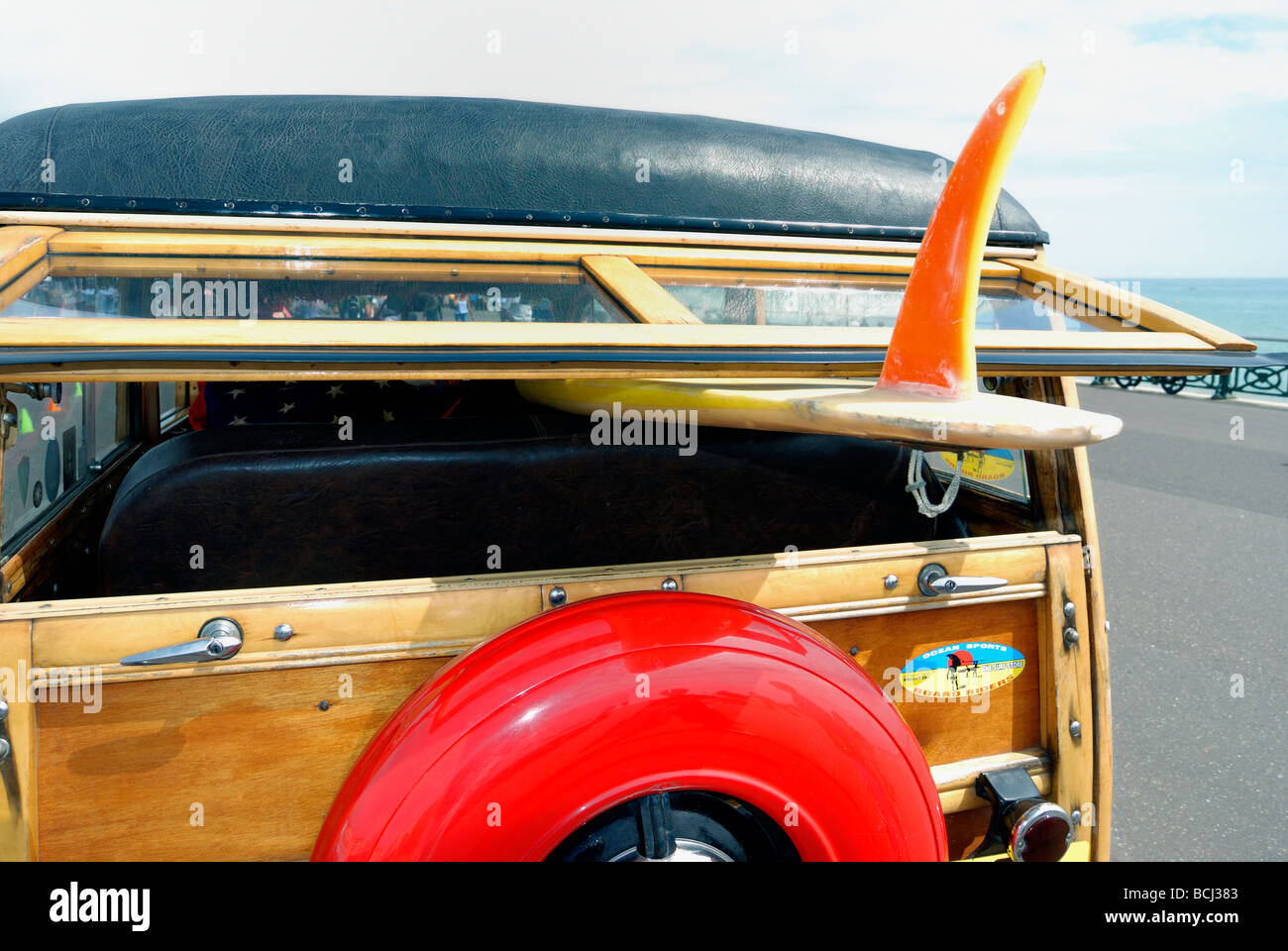 A surfboard loaded on a classic old car Stock Photo