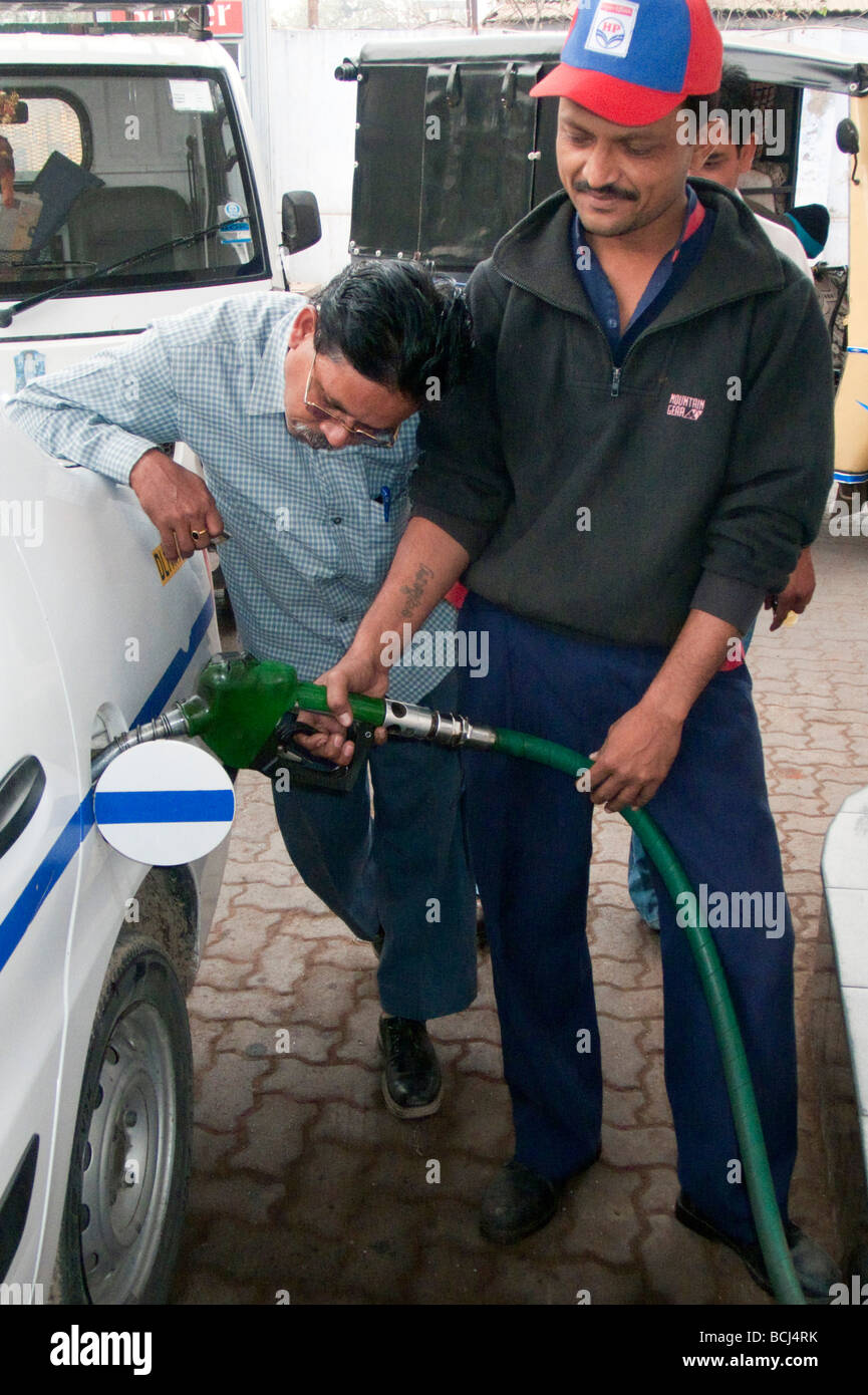 Driver checks taxi fuel level as taxi tank is filled with diesel India Stock Photo