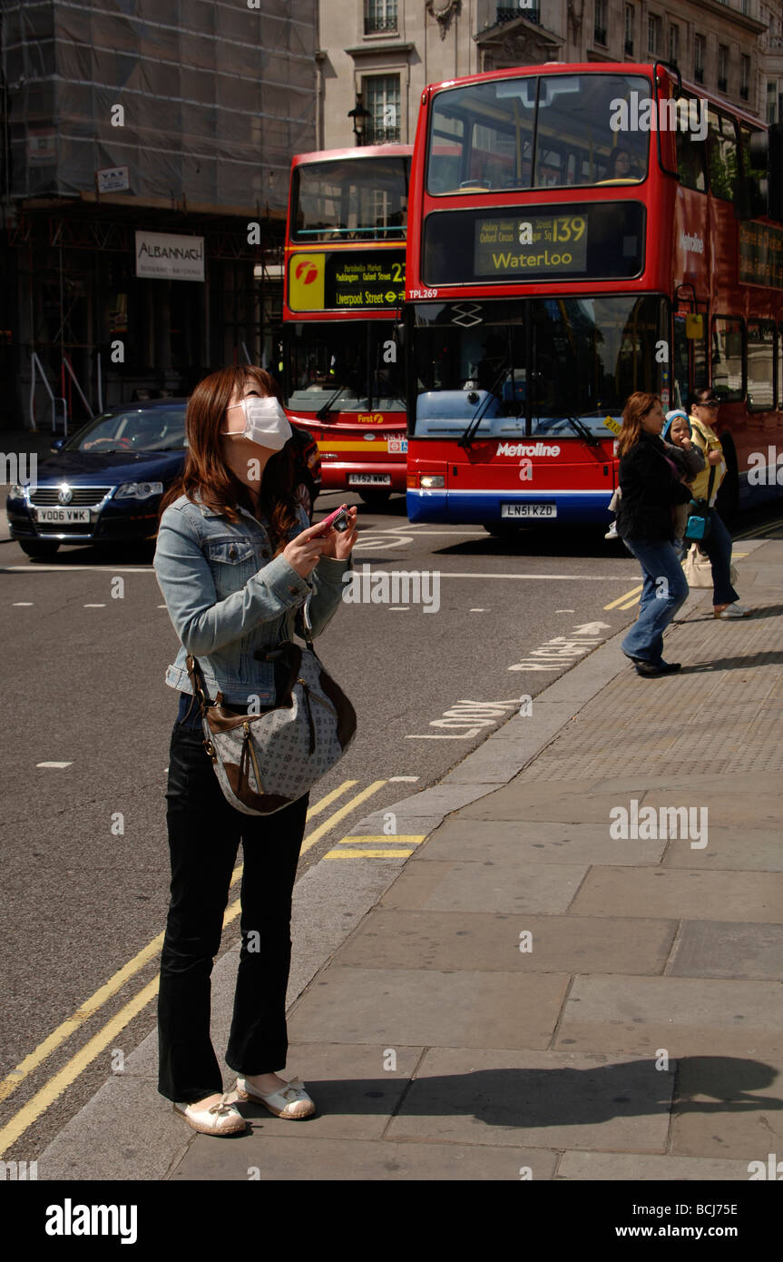 asian girl tourist wearing a protective face mask to prevent Covid Coronavirus in trafalgar square London Stock Photo