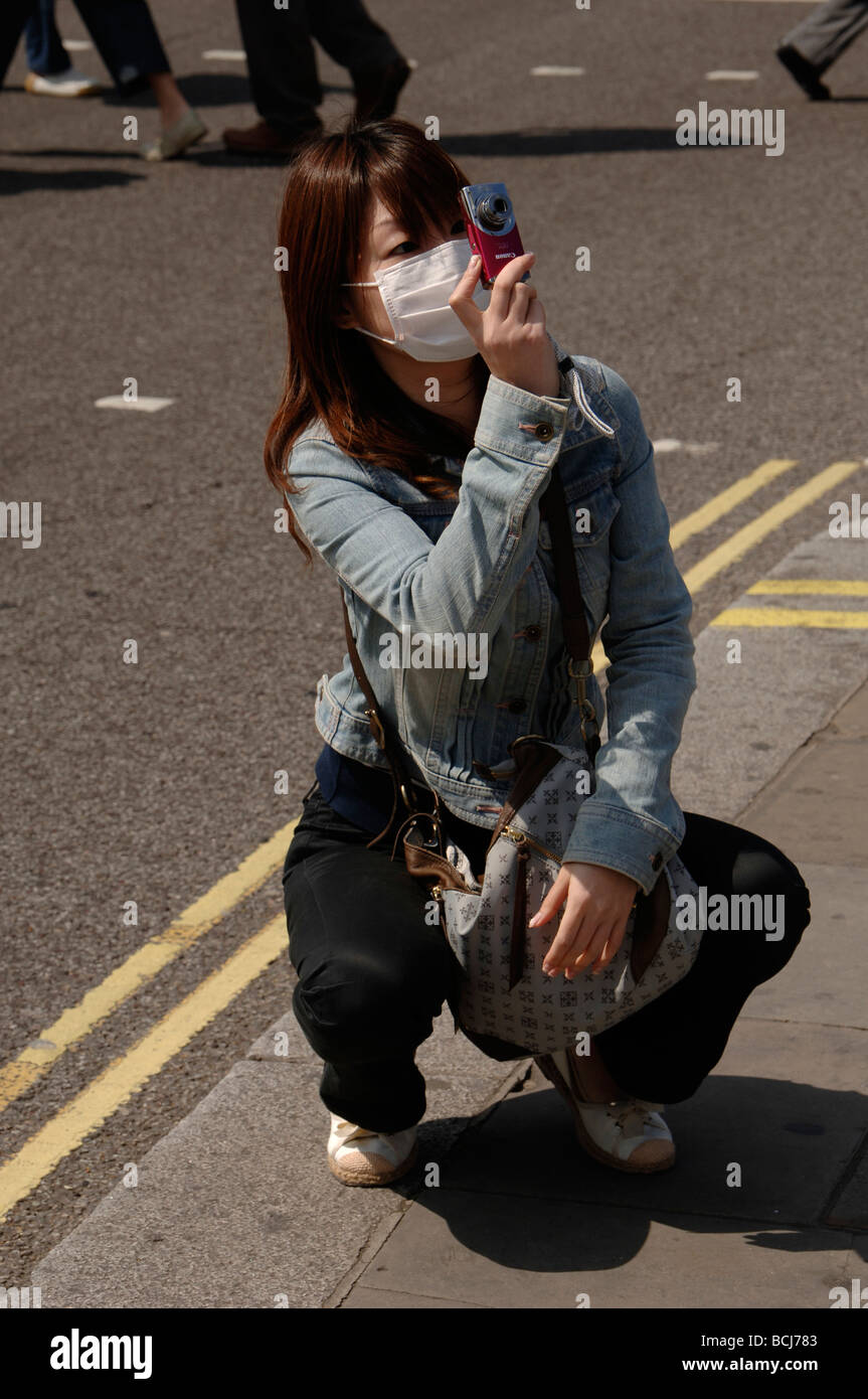 asian girl tourist wearing a protective face mask to prevent Covid Coronavirus in trafalgar square London Stock Photo