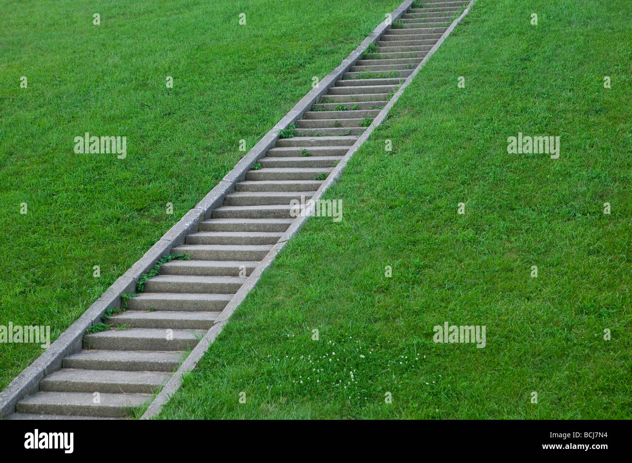 Diagonal pattern of concrete steps on grass covered hillside Stock Photo