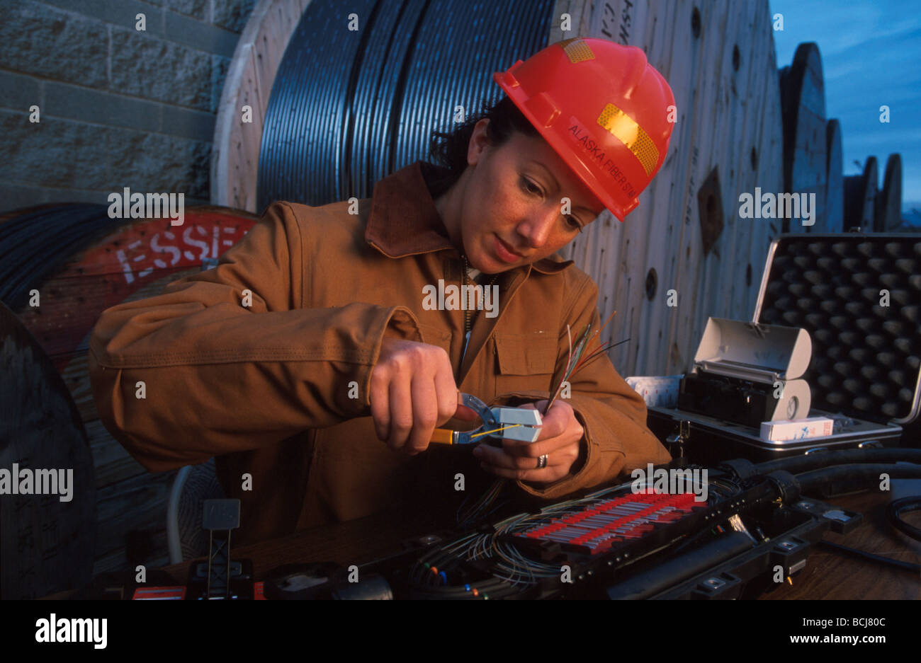 Female Telecommunication Worker Splicing Fiber Optic Cable AK Fiberstar Stock Photo