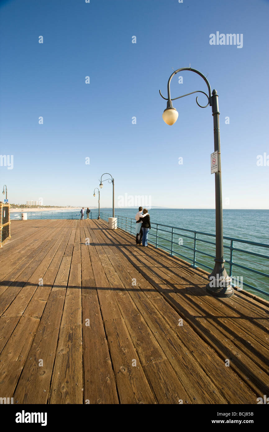Male and female couple standing at railing looking at view of ocean from Santa Monica Pier in Santa Monica, California, USA Stock Photo