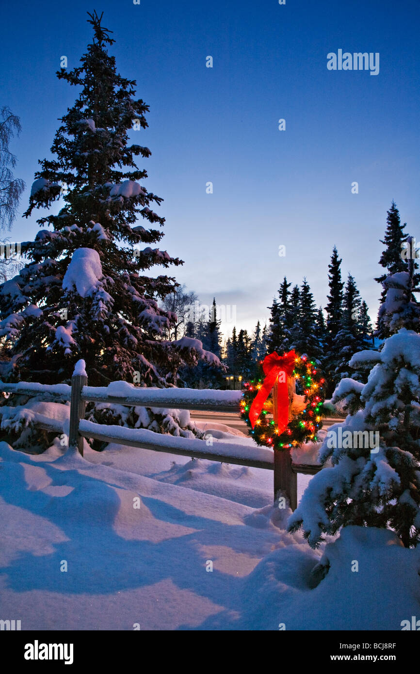 Decorated Christmas wreath hangs on a snowcovered split rail fence at ...