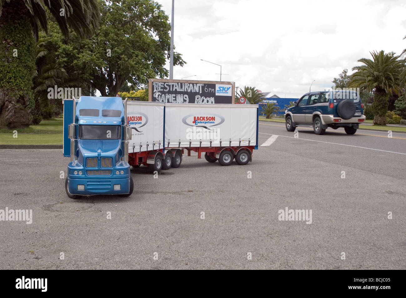 Small scale truck on road as normal sized pick-up drives past, New Zealand Stock Photo